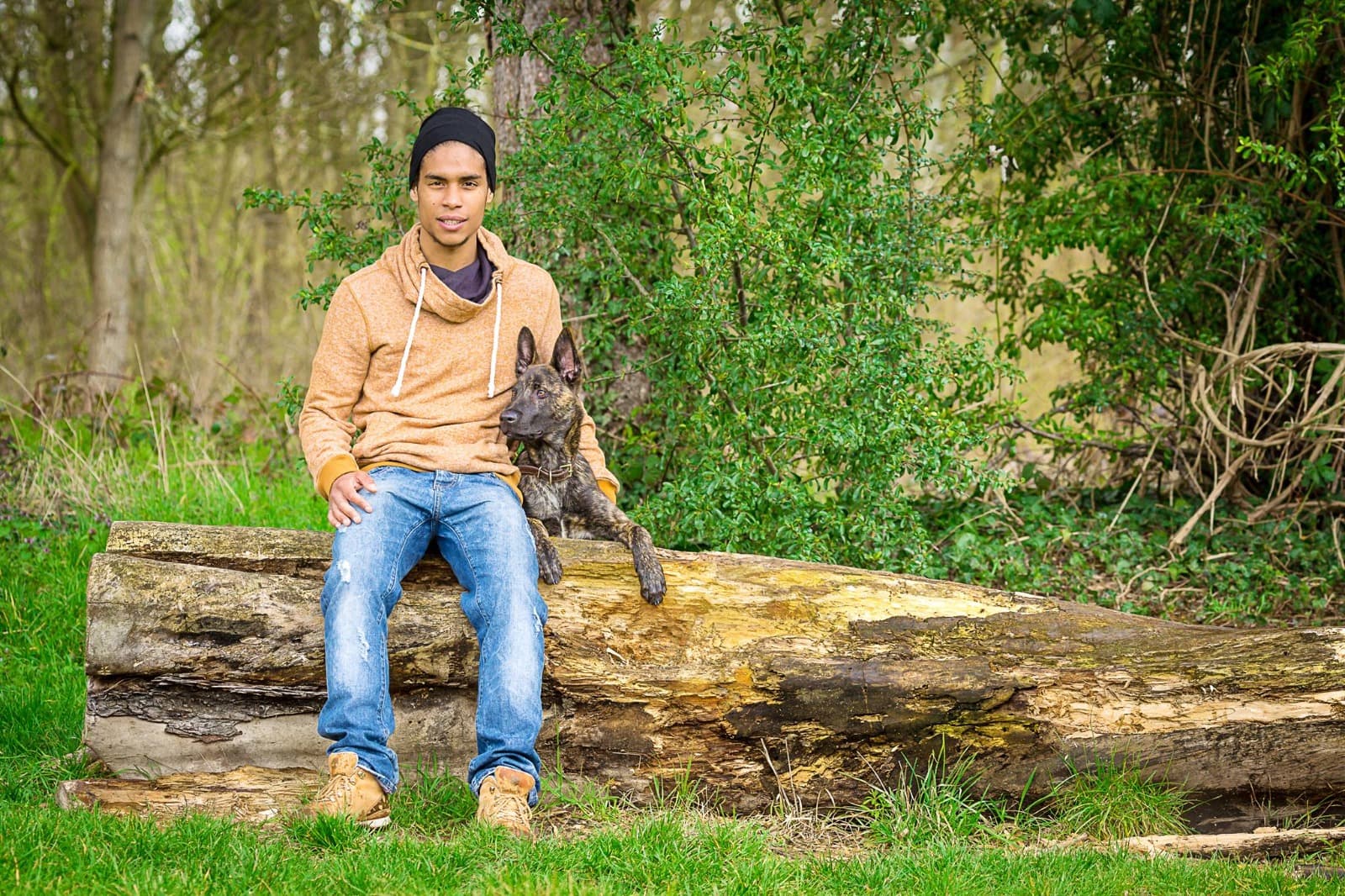 Romain debout avec malinois assis, gilet orange